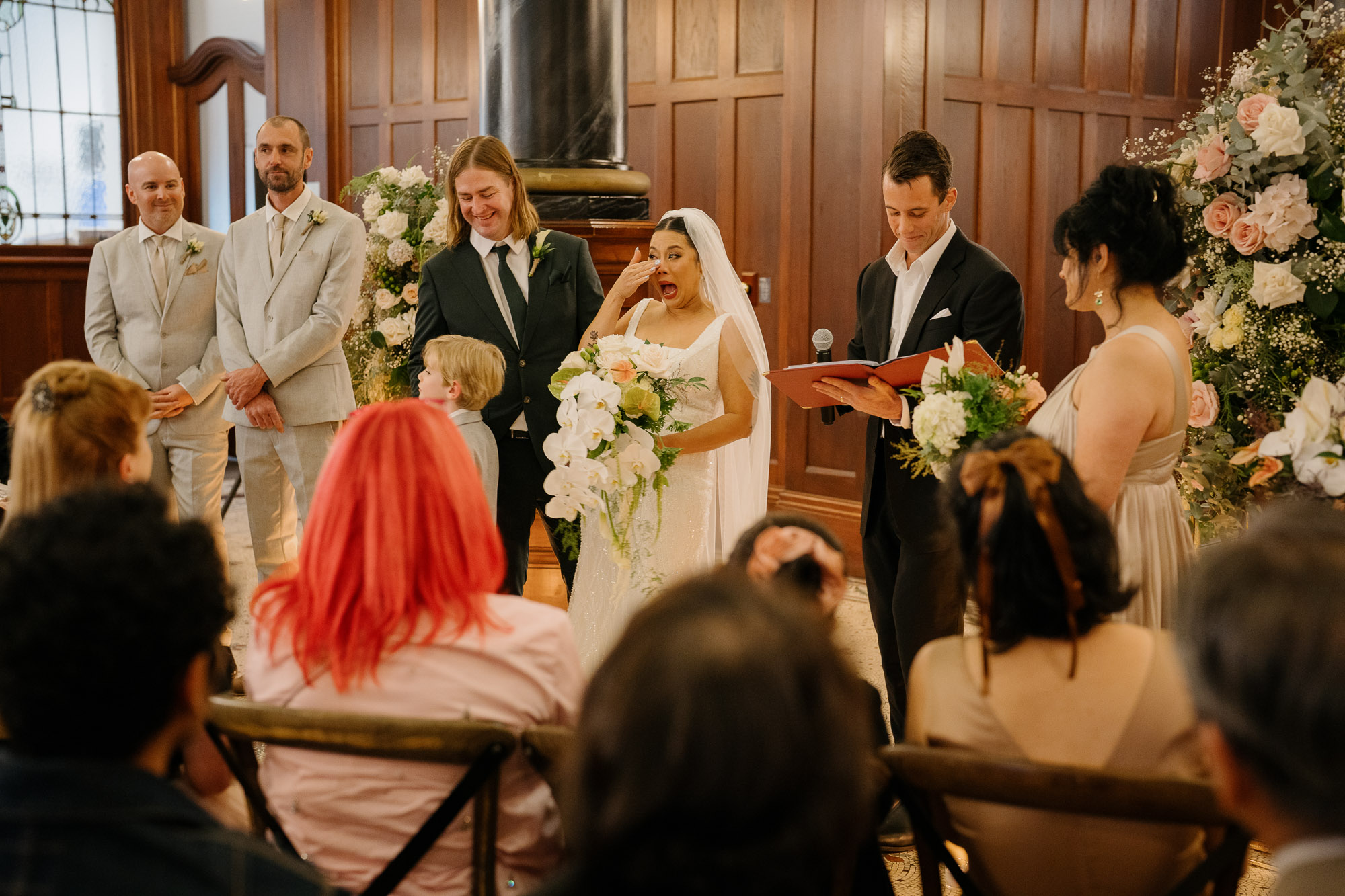 Bride wiping a tear during her wedding ceremony